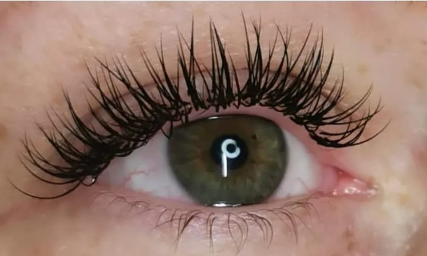 Œil vert-brun après une pose complète d'extensions de cils mixtes