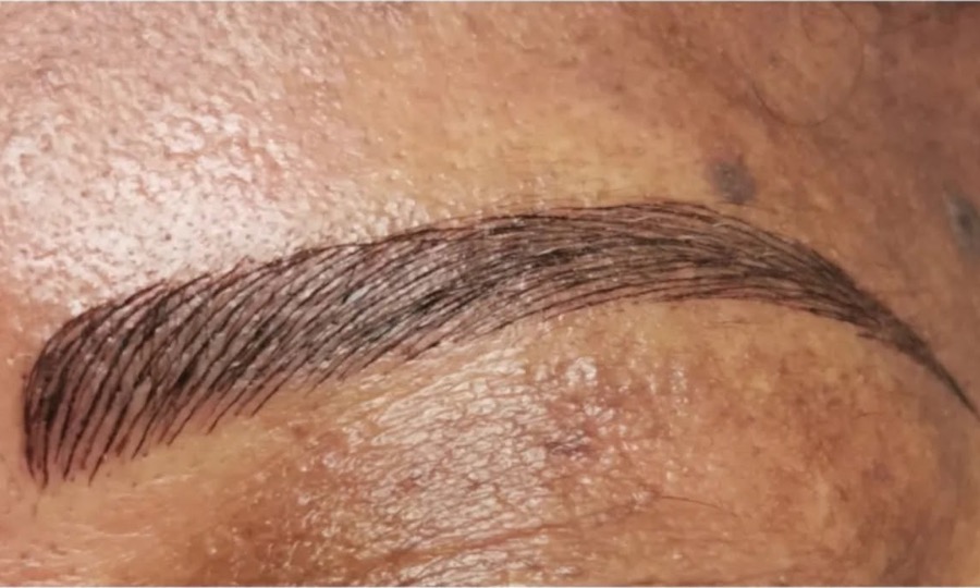 Sourcil redessiné en microblading sur peau mate